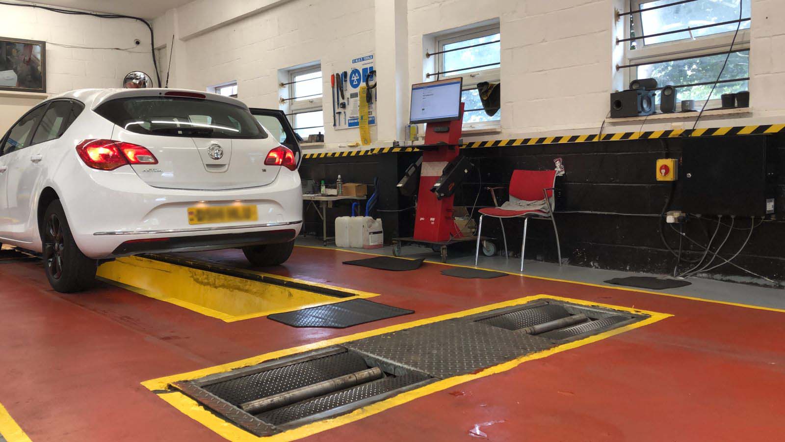 Professional mechanic smiling in a modern, clean workshop